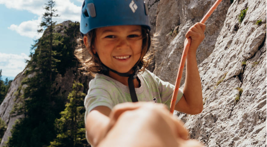 boy climbing smiles happily into the camera