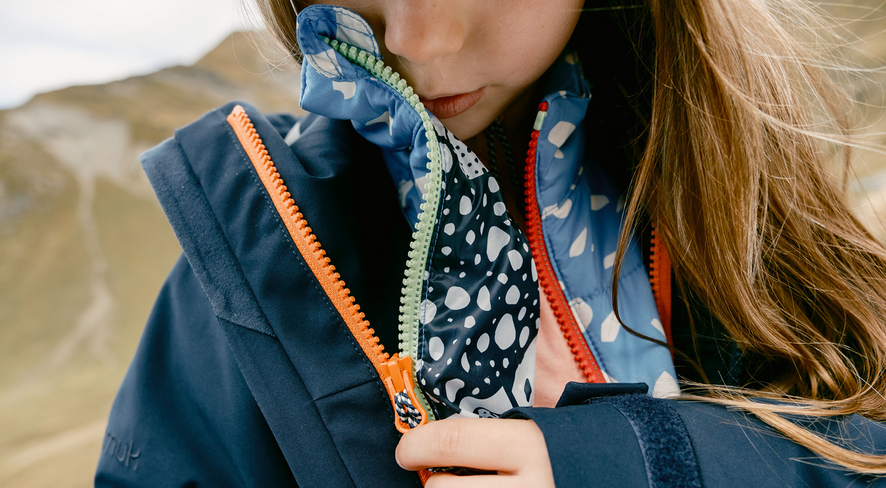 A child connecting his zip-in jackets