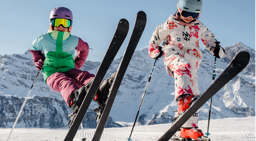 Two kids in namuk ski clothing standing on skis