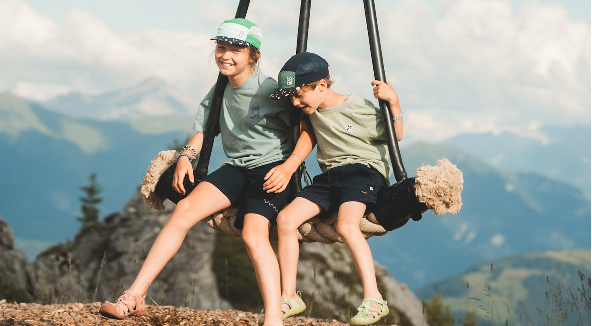 Kids from The Nomads Family on a swing in Laax